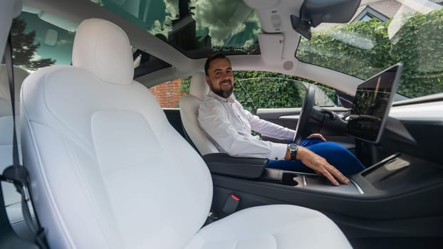 Caucasian bearded man in a suit driving a car