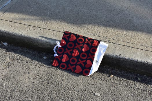 Discarded Heart Gift Bag in New York City Gutter. High quality photo