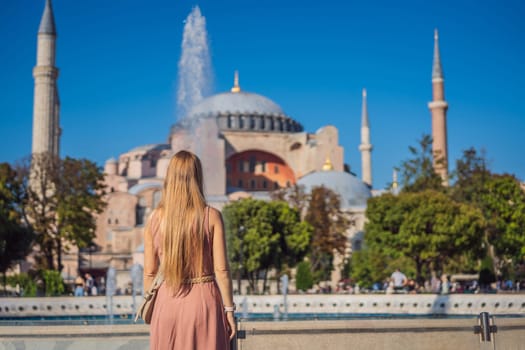 Woman enjoy beautiful view on Hagia Sophia Cathedral, famous islamic Landmark mosque, Travel to Istanbul, Turkey. Sunny day architecture and Hagia Sophia Museum, in Eminonu, istanbul, Turkey. Turkiye.