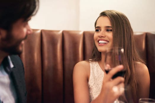 Happy couple, valentines day and restaurant date with wine, love and happy communication to celebrate. Young man and woman together for fine dining, drinks and romantic dinner for holiday celebration.