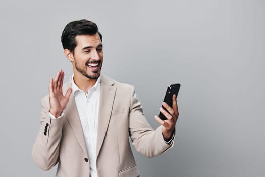 gray man handsome business hold beige call smartphone cyberspace trading white corporate happy phone mobile studio person young smile suit portrait
