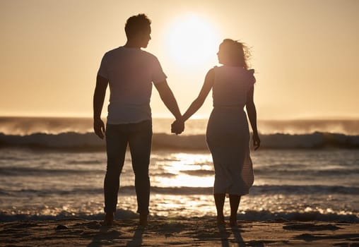Beach silhouette, couple holiday and sunset with love, hold hands and love together, support and holiday. Man, woman and vacation at ocean, travel and romance for anniversary, honeymoon and sea trip.