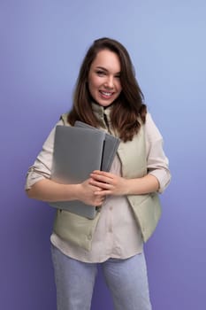 confident 30s woman boss business with a stack of documents and a laptop in her hands.