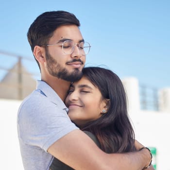 Love, beach and happy couple hug, relax and enjoy outdoor quality time together for peace, freedom and romantic date. Happiness, sky and man and woman bond on travel holiday in Rio de Janeiro Brazil.