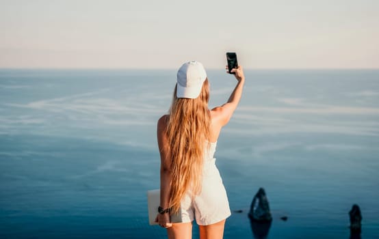 Woman travel sea. Young Happy woman in a long red dress posing on a beach near the sea on background of volcanic rocks, like in Iceland, sharing travel adventure journey