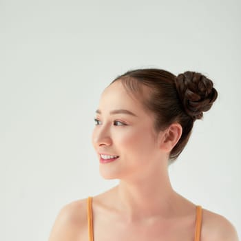 Modern playful girl with two hair buns smiling looking up dreamily. 
