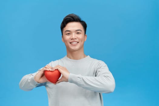 Young man holding heart in his hand. 