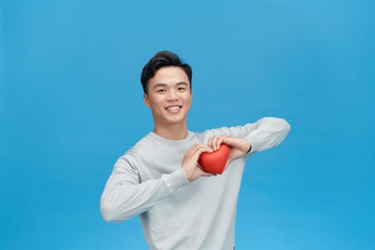 man holding heart smiling with a happy and cool smile on face.