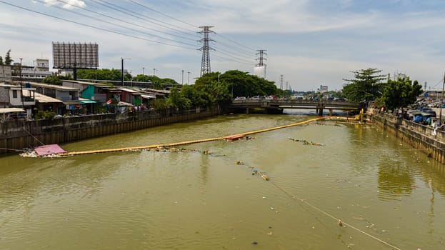 Polluted Ciliwung river with garbage in the slums of Jakarta, Indonesia.