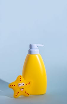 Yellow layout of a children's cosmetic product with a place for a logo and funny rubber toy. Baby sun protection, sunscreen or body lotion. Space for text. Summer protection concept