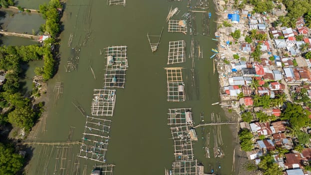 Top view of fish farm with cages and nets on the river. fishing village. Hinigaran River. Negros, Philippines