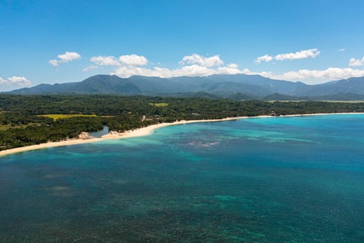 Seascape with tropical sandy beach and blue ocean. Pagudpud, Ilocos Norte, Philippines.