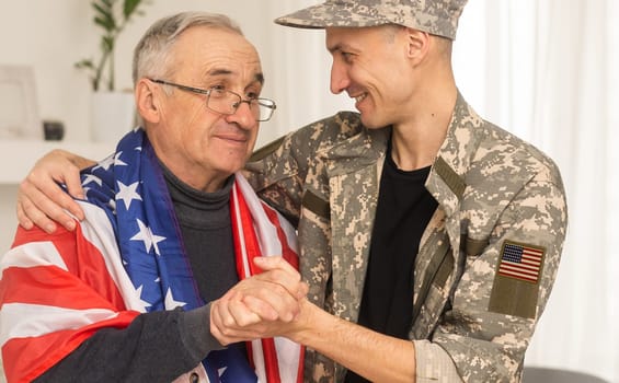 Happy young soldier smiling cheerfully while standing outside his home. Patriotic American serviceman coming back home after serving his country in the military.