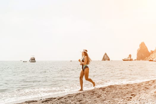 Woman travel summer sea. A happy tourist in a blue bikini enjoying the scenic view of the sea and volcanic mountains while taking pictures to capture the memories of her travel adventure