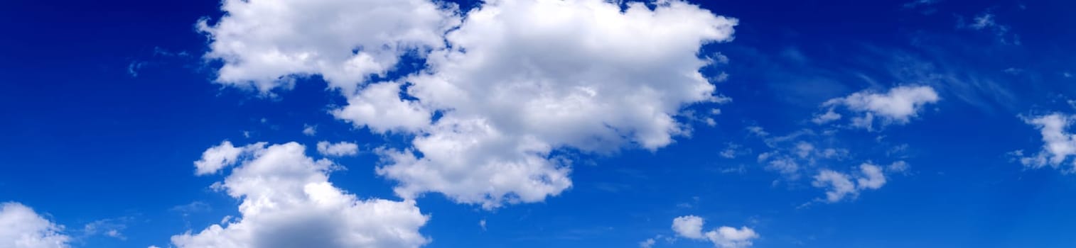 Blue sky background with white clouds. Cumulus white clouds. Panoramic image