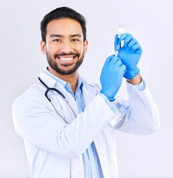 Portrait of doctor with smile, syringe and vaccine in studio for healthcare, medicine and innovation in medical science. Vaccination, booster shot and Indian man, virus protection on white background.