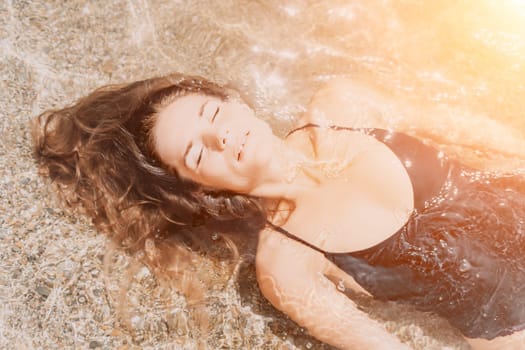 Woman travel sea. Young Happy woman in a long red dress posing on a beach near the sea on background of volcanic rocks, like in Iceland, sharing travel adventure journey