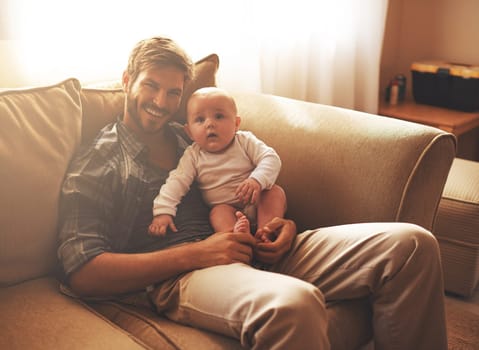 Hes growing up so fast. Cropped portrait of a young father and his baby boy in the living room
