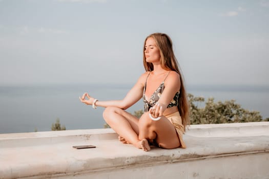 Woman park yoga. Side view of free calm bliss satisfied woman with long hair standing in morning park with yoga position against of sky by the sea. Healthy lifestyle outdoors in park, fitness concept