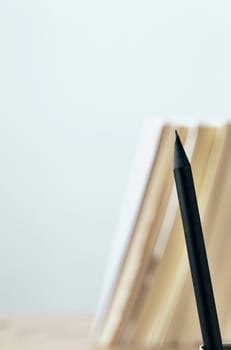 One black  pencil  and books on table ,place of work or leisure time