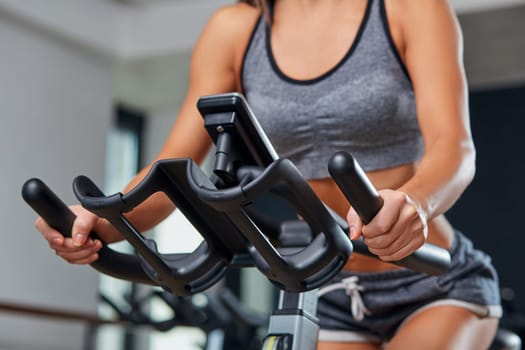 Sport young woman on a stationary bike in the gym