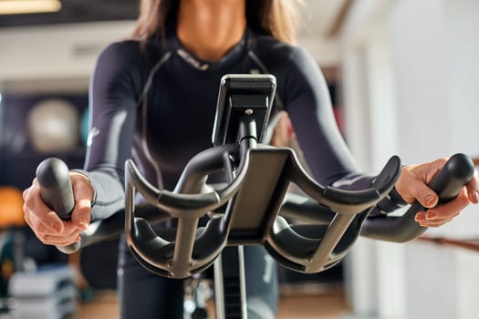 Strong female hand on a stationary bike in the gym