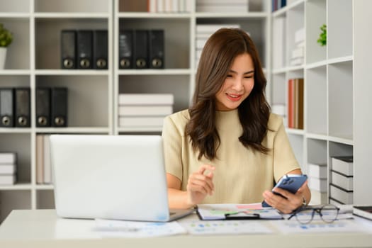 Young woman financial advisor using smartphone, checking communicating online or consulting client distantly.