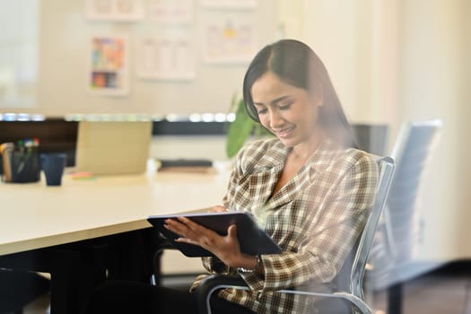 Charming female manager writing idea for startup project or reminder schedule note on notebook.