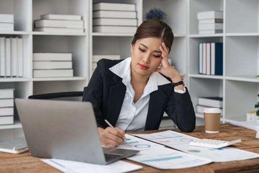 tired business woman sleepy and bored from sitting at a desk for a long time and has office syndrome.