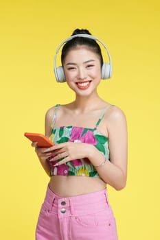 cheerful nice woman wearing headphones modern technology standing near empty space with telephone