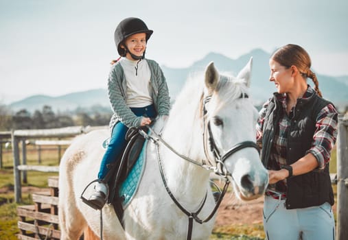 .Happy child on horse, woman with harness on ranch and mountain in background lady and animal walking on field. Countryside lifestyle, rural nature and farm animals, mom girl kid to ride pony in USA