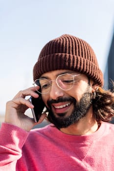 portrait of a stylish young man smiling happy talking on smart phone, concept of modern lifestyle and technology of communication, copy space for text