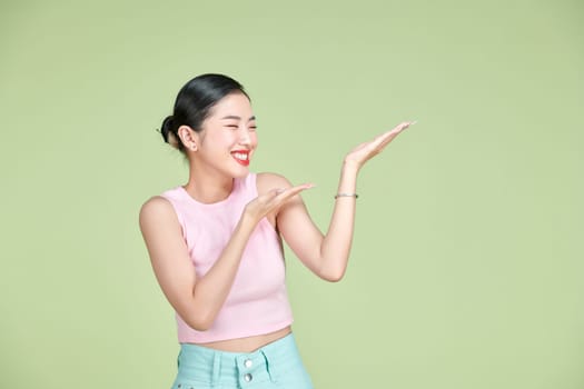 Smiling woman showing open hand palm with copy space for product or text
