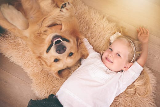 Girl, dog and portrait together on floor in living room or golden retriever, kid and smiling with pet above lounge carpet. Young child, Labrador and happiness or family home, pets and top view.