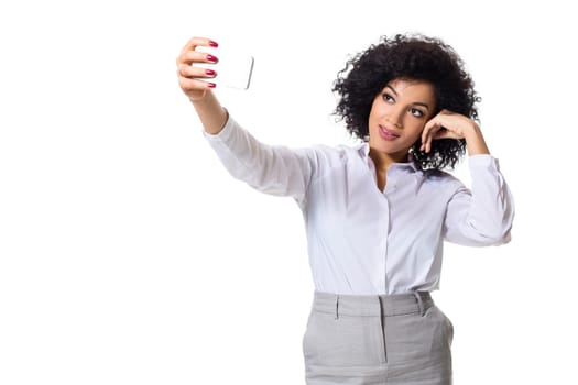 Beautiful brunette woman in classic white shirt and skirt make selfie on the phone. White background. Isolated