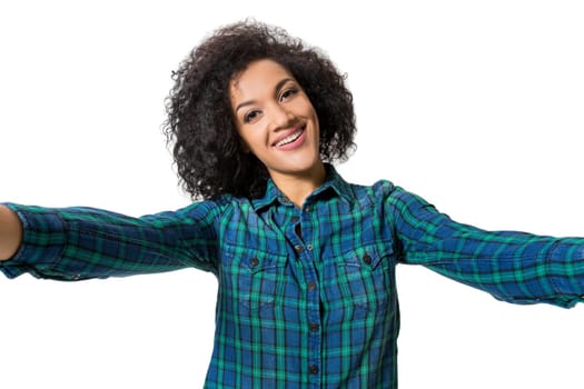 Young beautiful African American woman makes self against the white background in studio. Emotions. Isolated on white background