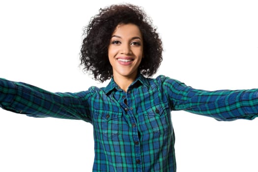 Young beautiful African American woman makes self against the white background in studio. Emotions. Isolated on white background