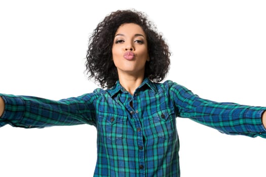 Young beautiful African American woman makes self against the white background in studio. Emotions. Isolated on white background