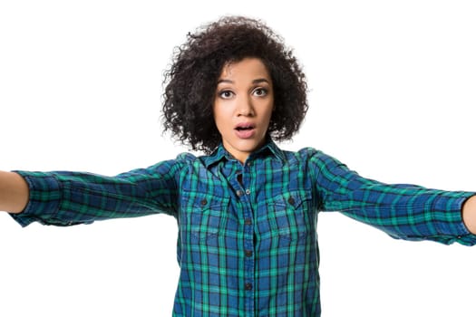 Young beautiful African American woman makes self against the white background in studio. Emotions. Isolated on white background