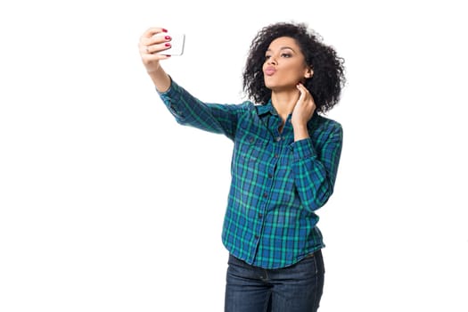 Young woman in blue shirt makes selfie on a white background. isolated