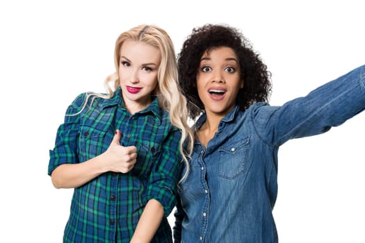 Two beautiful girls making selfie. Isolated on white background. young woman looking into the camera