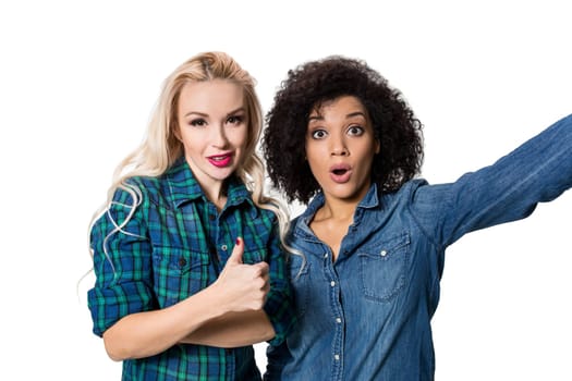 Two beautiful girls making selfie. Isolated on white background. young woman looking into the camera