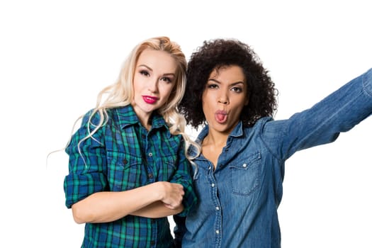 Two beautiful girls making selfie. Isolated on white background. young woman looking into the camera