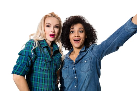 Two beautiful girls making selfie. Isolated on white background. young woman looking into the camera