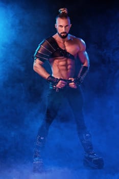 Handsome young sexy man with beautiful muscular chest in interesting costume on the scene. The Stripper man. Show time