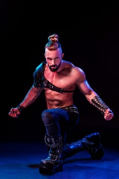 Handsome young sexy man with beautiful muscular chest in interesting costume on the scene. The Stripper man. Show time