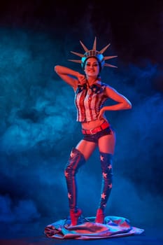 Young woman in stage costume of striptease dancer posing. Sexy woman in a statue of America costume