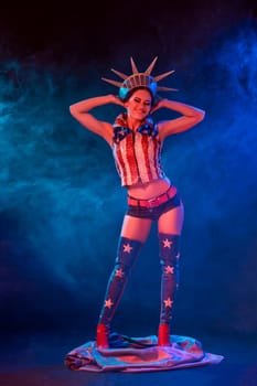 Young woman in stage costume of striptease dancer posing. Sexy woman in a statue of America costume