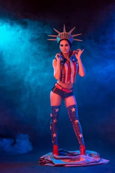 Young woman in stage costume of striptease dancer posing. Sexy woman in a statue of America costume