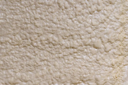 Close-up of the walls of the building insulated with polyurethane foam. Background texture of the Two-component mounting foam for insulating of the wall. insulation of walls and roofs of buildings with polyurethane foam. Construction foam. foam structure. The surface of dried polyurethane foam.